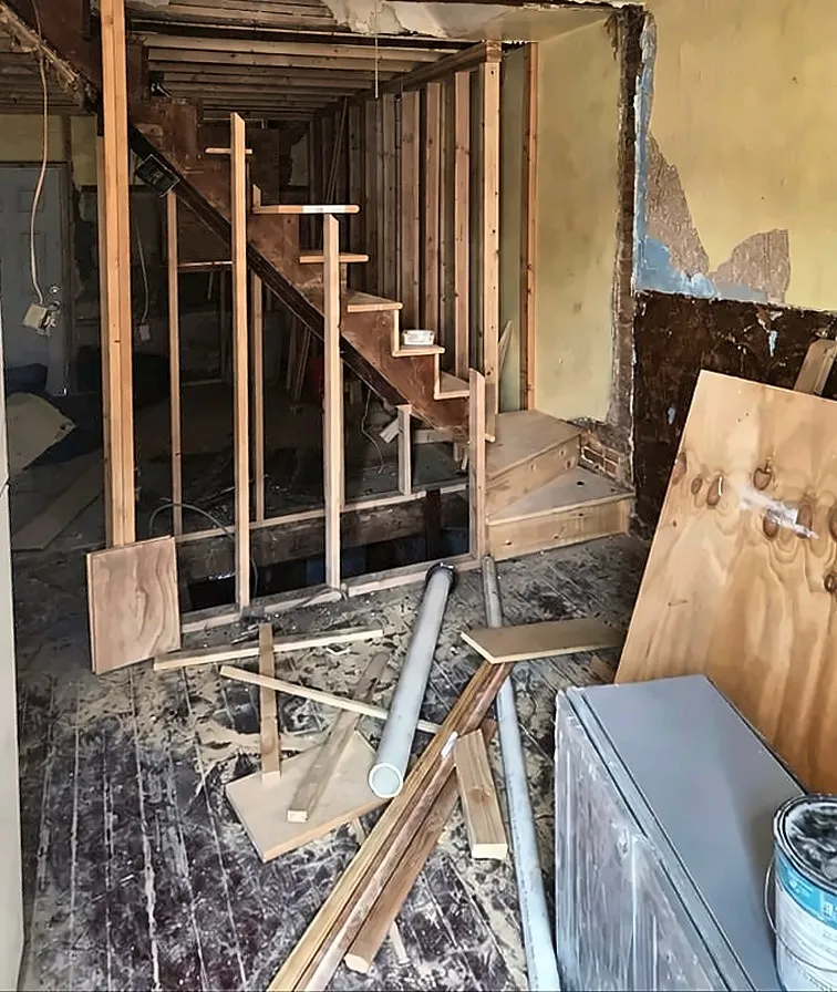 Before: Before and after of a gutted stairwell turned into a finished entry hall