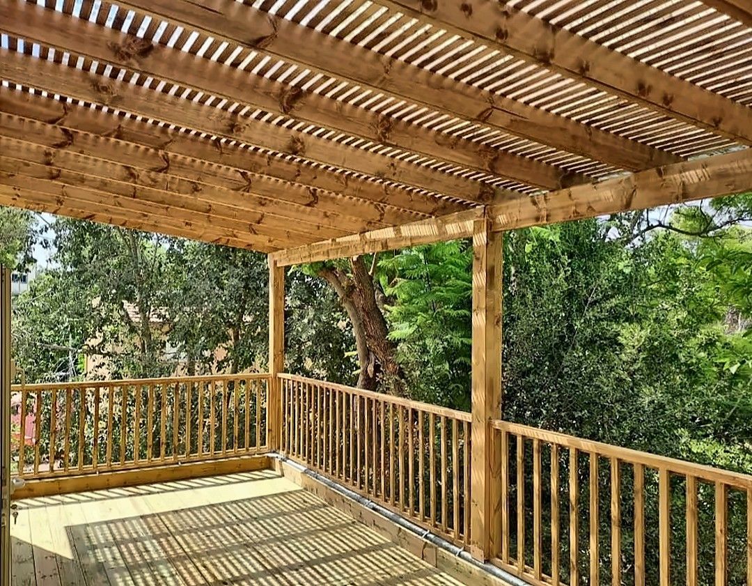 New wood deck with railings and a slatted pergola roof